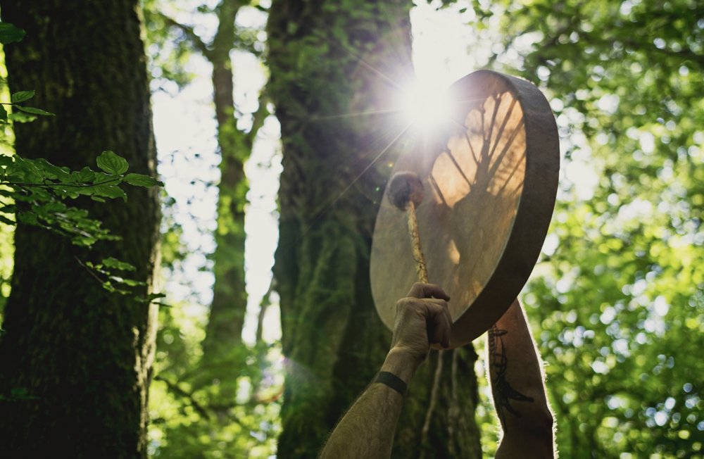 Playing a hand drum in the forest sunlight